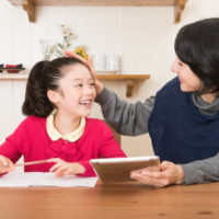 子供の勉強をみるお母さん